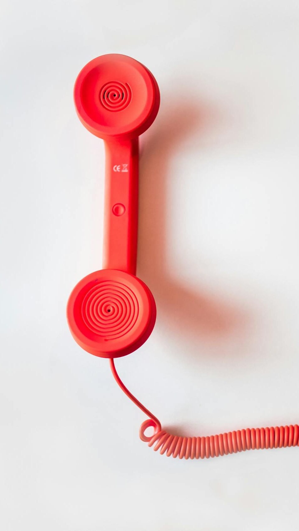 Red Corded Telephone on White Suraface